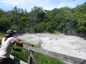 woman watching bubbling mud pools