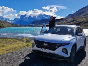 Woman leaning out of car with dramatic landscape behind