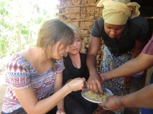 Travellers handling peas in a basket with local