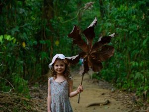 Young girl holding giant leaf