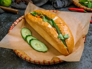 Banh mi on woven plate with sliced cucumber