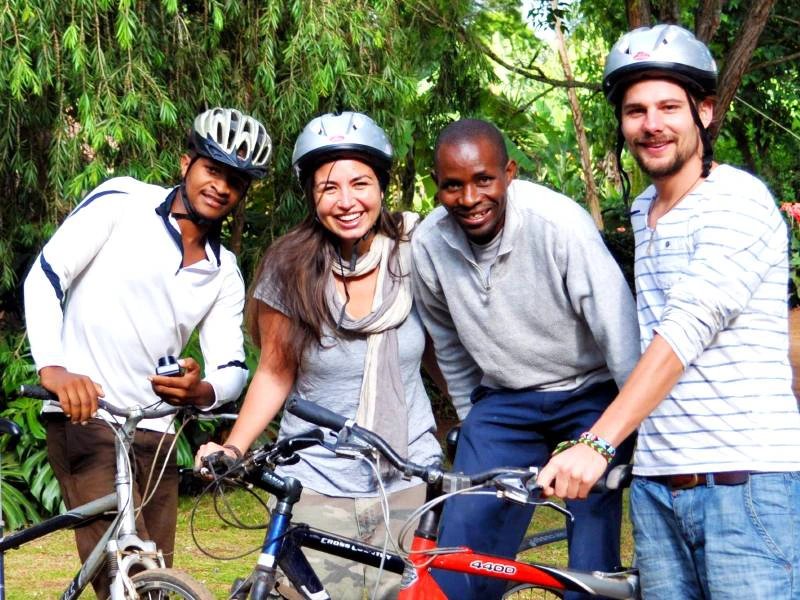 Travellers stood with locals wearing cycling helmets