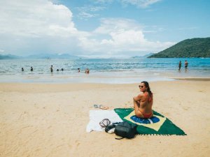 Woman sitting on the white sand beach of Ilha Grande