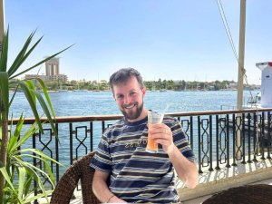man having a drink by the water