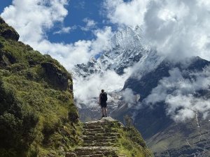 Man trekking up stone steps with mountain view