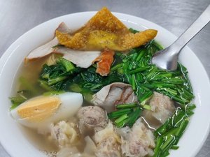 Bowl of hot broth with various toppings