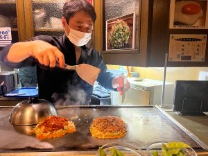 Chef wearing a mask cooking food in a kitchen 