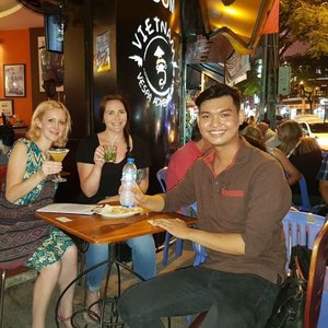 Vietnam local guide with tourists having a drink