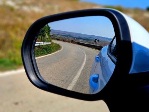 View of road reflection through wing mirror of car