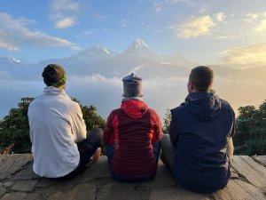 three people sat overlooking mountains