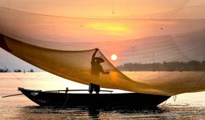Vietnam fisherman with net at sunset