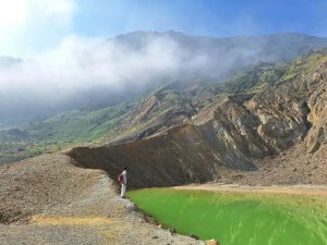 Person standing on the edge of Papandayan lake