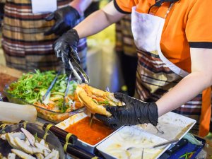 Local food vendor preparing a banh mi sandwich in Vietnam