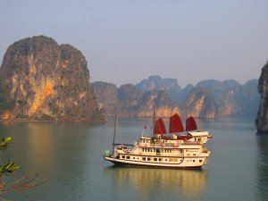 Boat floating along bay with limestone cliffs