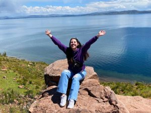 lady on rock in front of lake