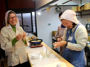 Two women laughing and cooking together