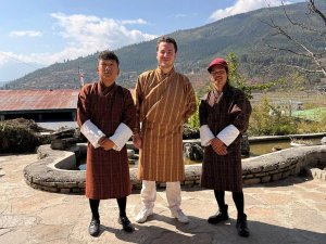 Tourist with local Bhutanese men all in local dress