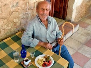 Local man sitting at a table in Greece