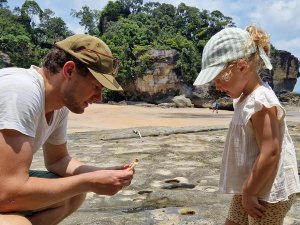 Small girl and father on the sand in Bako National Park