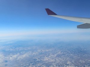 Domestic flight view of wing in air and land below