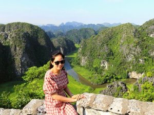 Woman sitting at viewpoint with cliffs in the distance