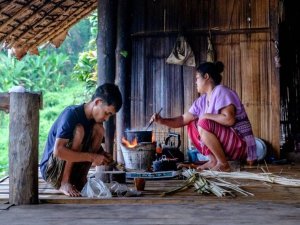 Two local people cooking in rural setting