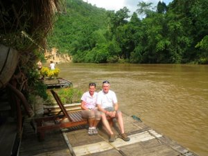 travellers on floating river hut Thailand