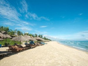 Beach with straw parasols and sun loungers