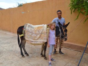 man with donkey and child