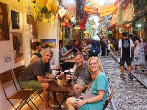 Travellers sat around a table on Hanoi's train street