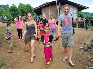 Thailand couple in village with local kids