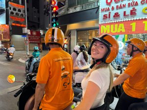 Woman on back of vespa wearing helmet