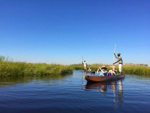 People on traditional Mokoro boat on river